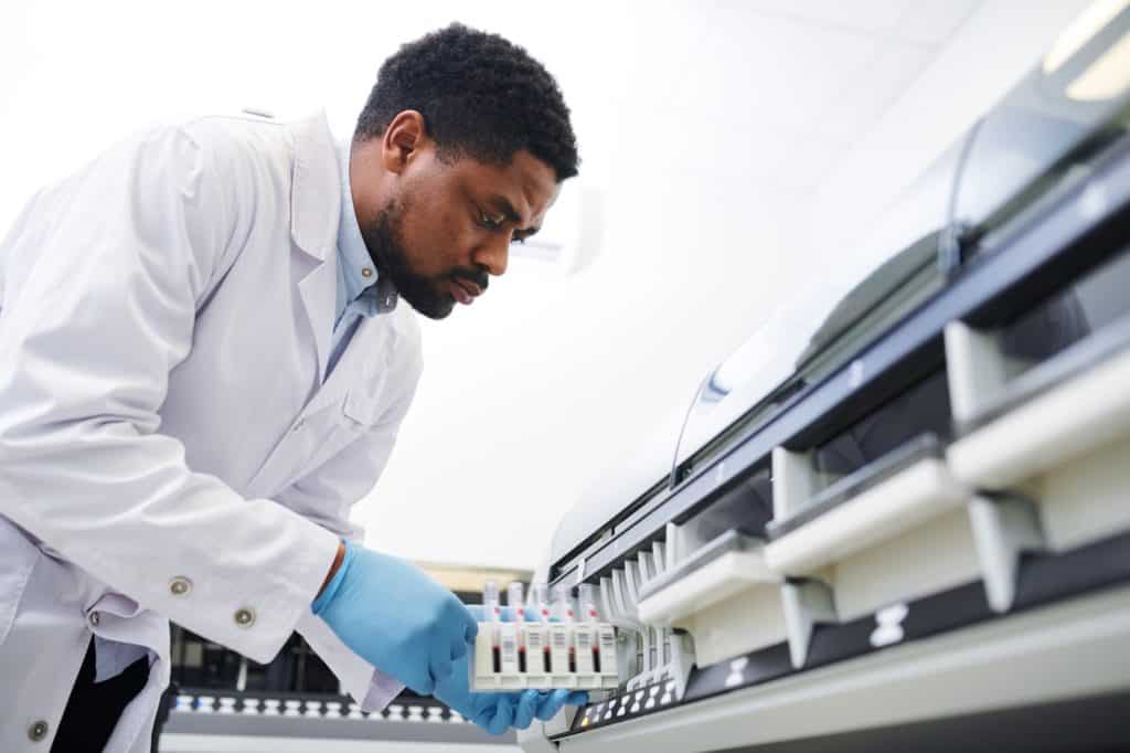 Black doctor working with pharmaceutical machine